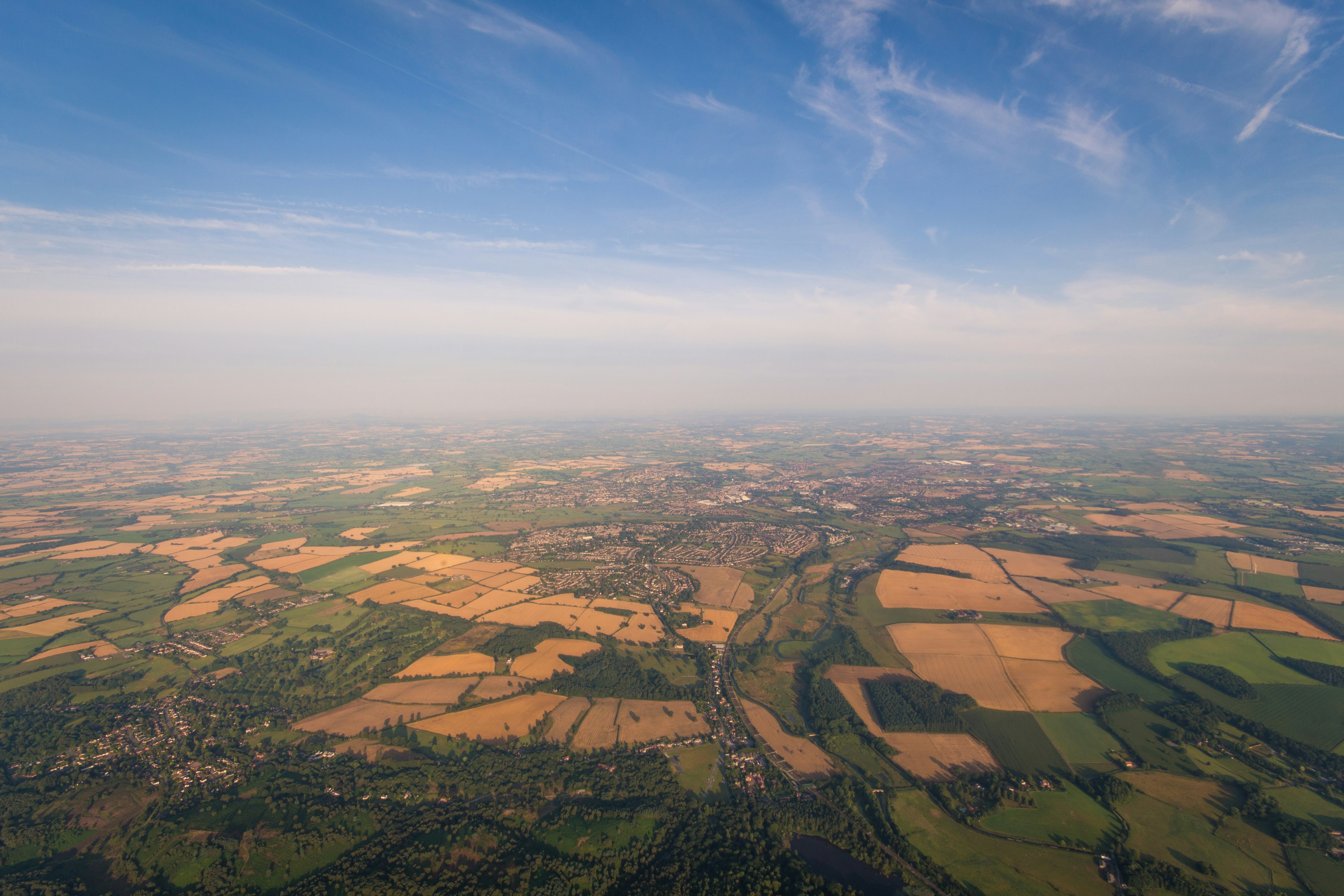 aerial photo of brown and green fields under blue sky during daytime